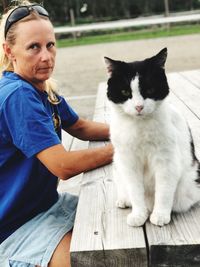 Portrait of woman sitting by cat