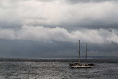 Sailboat sailing on sea against sky