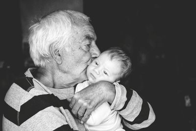 Grandfather kissing grandson at night