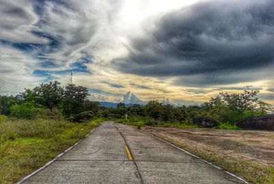 Empty road against cloudy sky