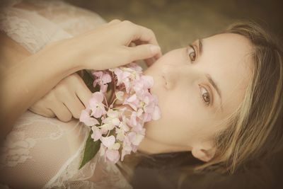 Close-up portrait of woman with pink flower