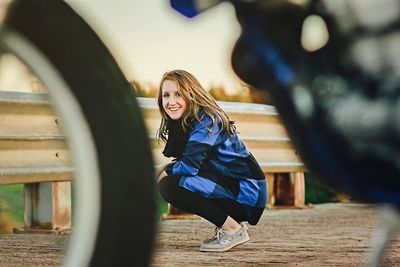 Portrait of smiling young woman against sky