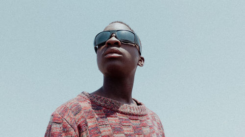 Low angle view of man wearing sunglasses against sky