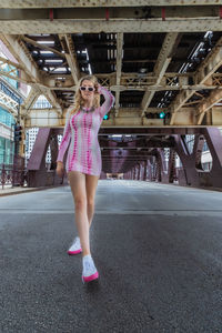 Full length portrait of woman standing on pink bridge