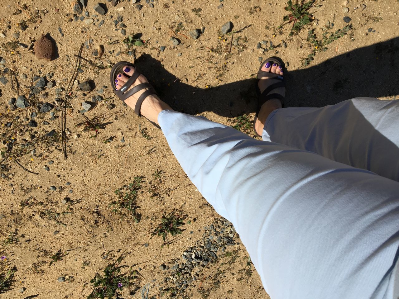 LOW SECTION OF WOMAN STANDING AT BEACH