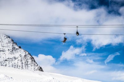 Low angle view of snowcapped mountains against sky