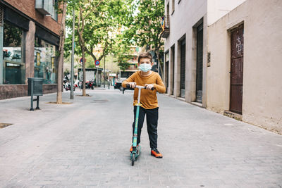 Full length of boy playing on push scooter