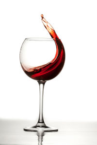 Close-up of wineglass on table against white background