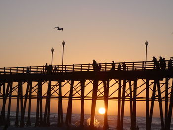 Silhouette of pier on sea against sky during sunset