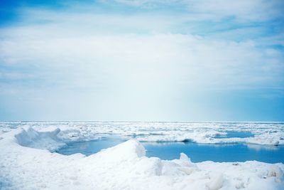 Snow covered landscape against sky