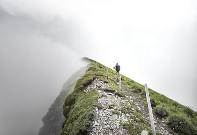 Man hiking on mountain against sky