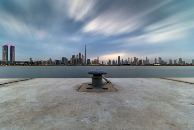 View of bollard by sea against buildings and sky