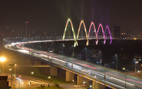 Light trails on bridge in city at night