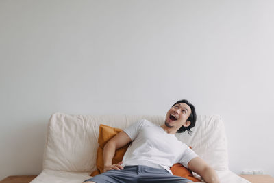 Cheerful man relaxing on bed at home