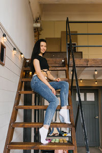 Young woman is sitting on the stairs in a house on the second floor person