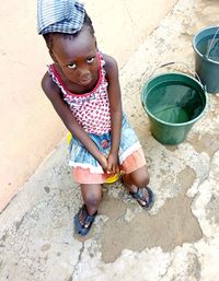 Young beautiful girl ready to carry a bucket of water home during the period of water shortage.