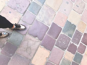 Low section of man standing on cobblestone