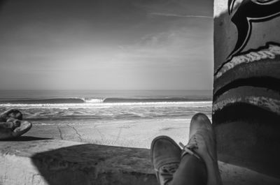 Low section of man relaxing on beach