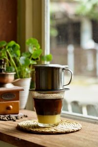 Close up of vietnamesse coffee drip on the table beside the window