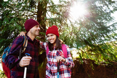 Young couple kissing against trees