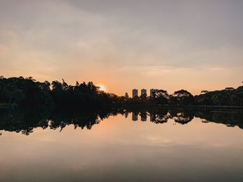 Reflection of trees in lake against sky during sunset