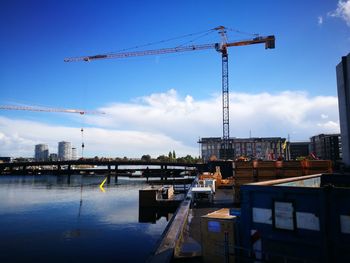 Cranes at construction site against sky