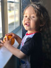 Cute boy looking away while standing at home