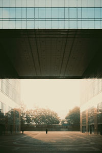 People walking on bridge against sky in city