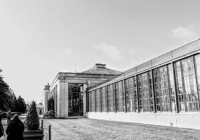 People on walkway by building against sky