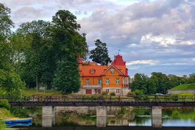 Building by river against sky