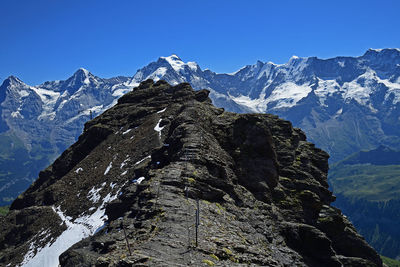 Scenic view of snowcapped mountains against clear blue sky