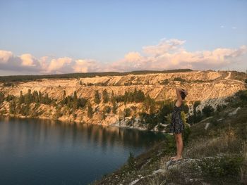 Side view of person standing on shore against sky