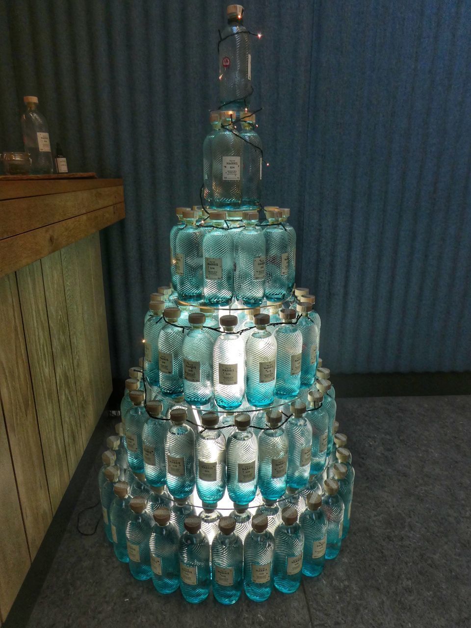 HIGH ANGLE VIEW OF BOTTLES IN GLASS ON TABLE