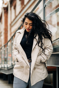 Young woman standing against wall