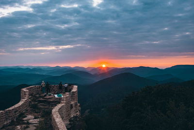 Scenic view of mountain against cloudy sky during sunset