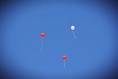 Low angle view of balloons against blue sky