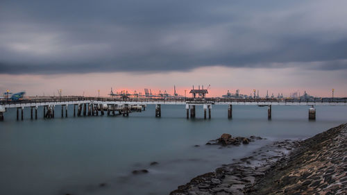 Scenic view of sea against cloudy sky during sunset