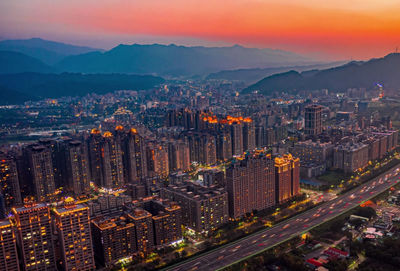 High angle view of city lit up at sunset