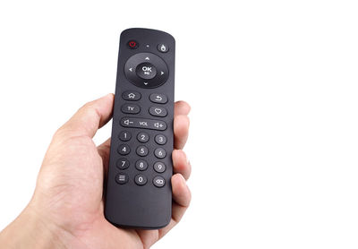 Midsection of person holding camera against white background
