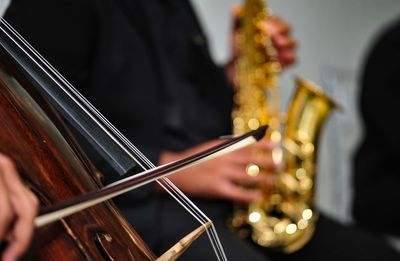 Cropped image of people playing violin and saxophone