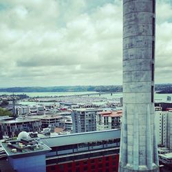 View of cityscape against cloudy sky