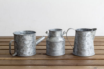 Metallic containers on wooden table