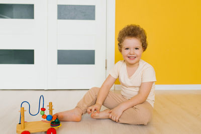 Child sit on the floor and play with wooden multi-colored car blocks