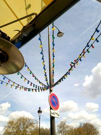 Low angle view of umbrellas hanging against sky