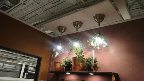 Low angle view of illuminated pendant lights hanging from ceiling at home