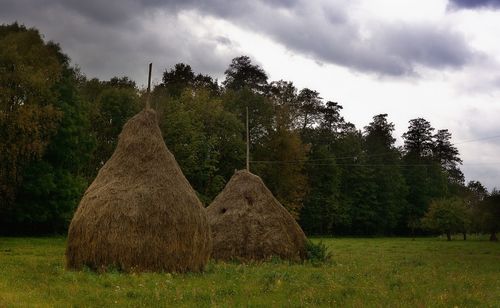 Hay bales on field against sky