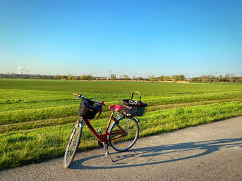 Bicycle on field against clear sky