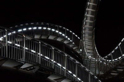 Low angle view of illuminated bridge against sky at night