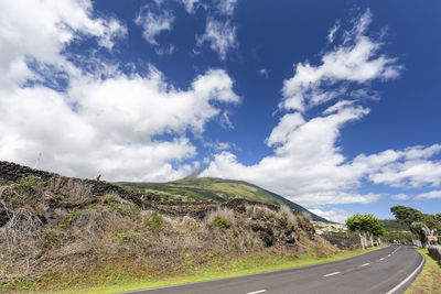 Empty road along landscape against sky