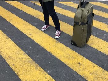 Low section of woman standing on road